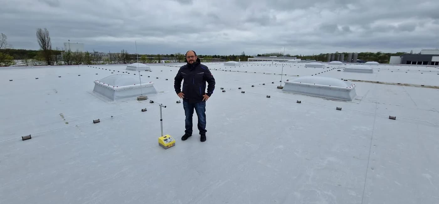 Messtechniker mit der Isotopensonde auf einer großen Flachdachfläche